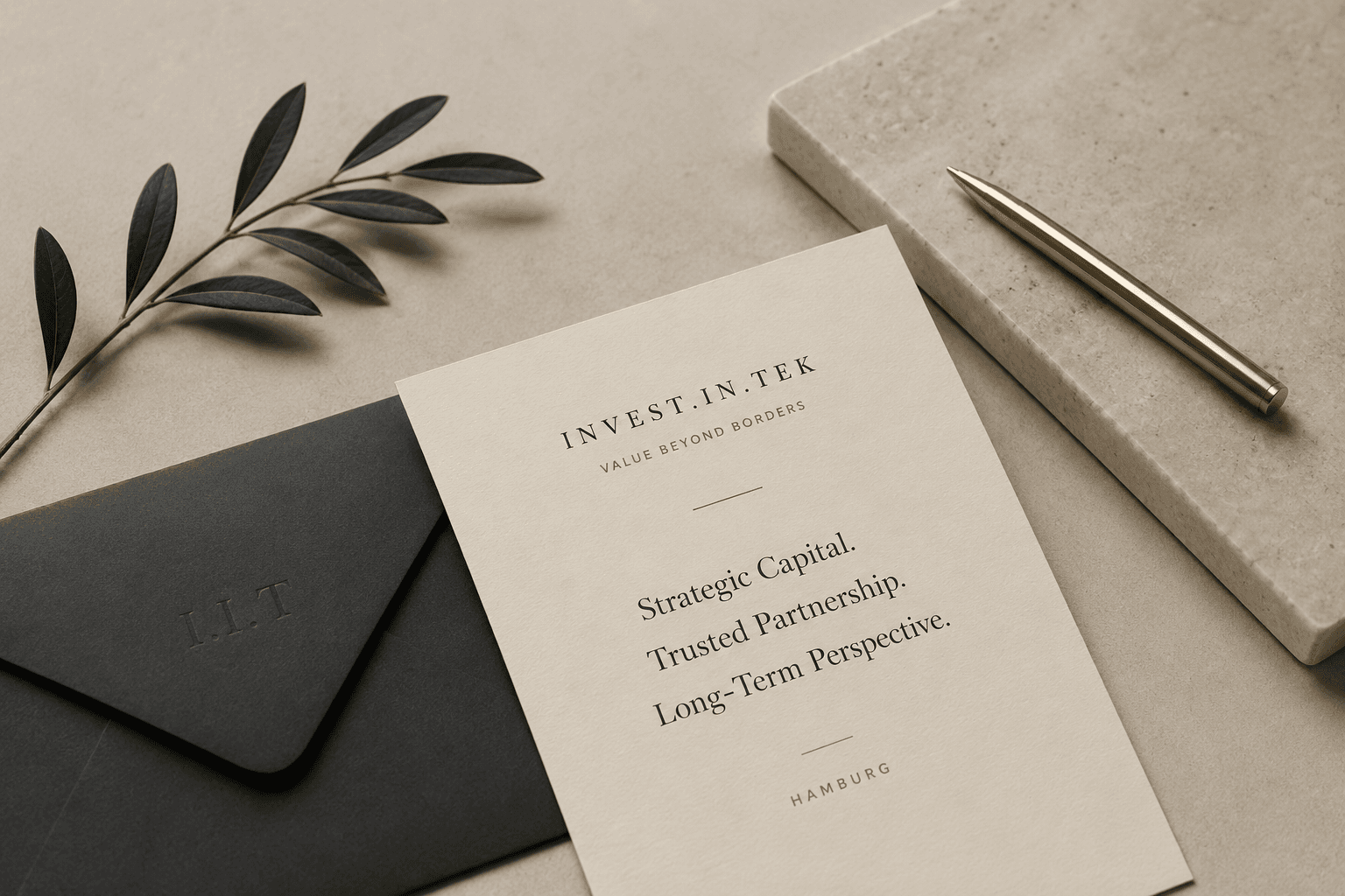 INVEST.IN.TEK branded correspondence — stationery, envelope, and pen on stone